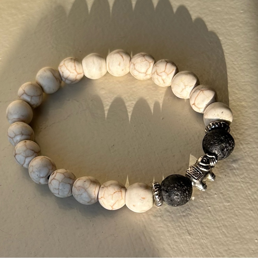 Ubud, Bali White and black lava stone bracelet with elephant charm